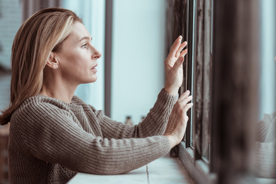 Concerned Woman Standing Near Window Feeling Depressed