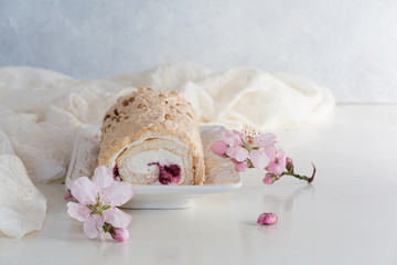 Fototapeta na wymiar Spring meringue cake roll with cream cheese and berry filling