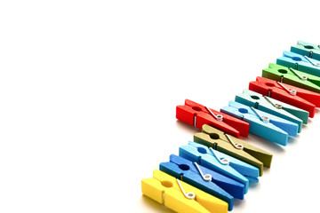 colorful wooden clothespins with one sticks out on a white background