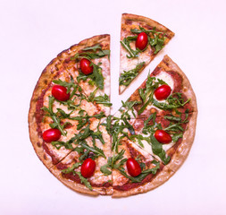 Flat lay pizza with arugula and cherry tomatoes on white background