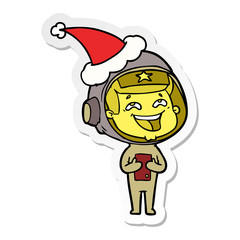 sticker cartoon of a laughing astronaut wearing santa hat