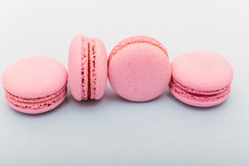 French pink macaroons cookies in rows on a light blue background