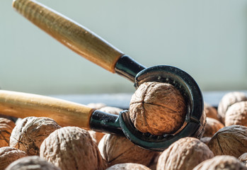 Nutcracker and lot of walnuts on table
