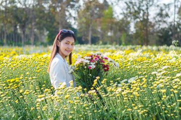 ฺBeautiful woman with flower boquet in park