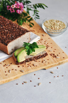 Healthy and proper Breakfast. Sandwich with avocado and homemade bread on sourdough of green buckwheat with flax seeds, sunflower. Raw and vegan food.