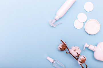 Plastic bottle with lotion, cotton swabs and cotton pads on a blue background