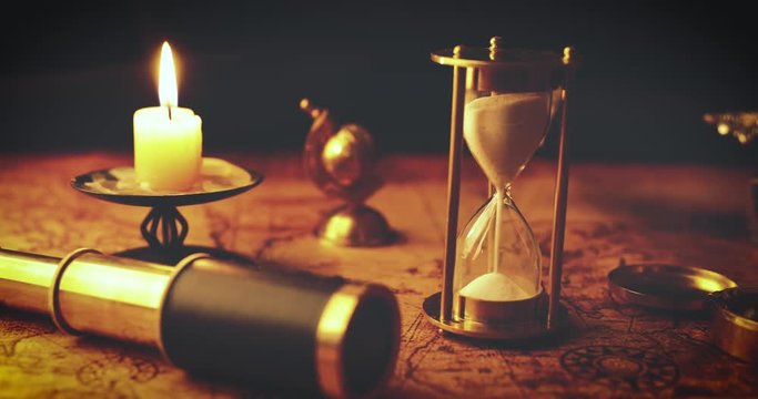 vintage nautical items on old world map in candlelight