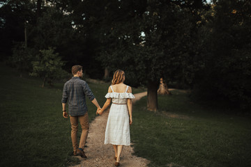 Young european couple walking in the forest and spending time together. Concept of relastionship, love and family.