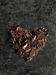heart shape chopped dark chocolate on dark background
