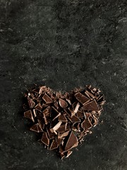 heart shape chopped dark chocolate on dark background