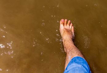 Feet of a man by the sea