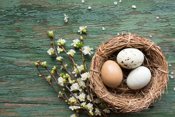 Easter eggs in straw nest on old wood