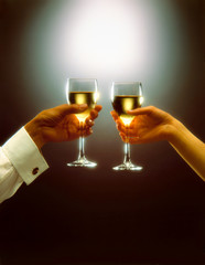 a man and a woman, toast with white wine over dark background