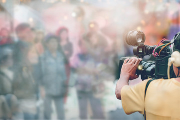 Video camera operator working with his equipment outdoors.