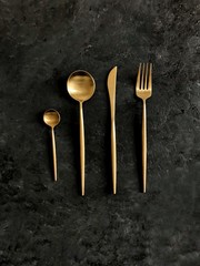 golden cutlery on dark background