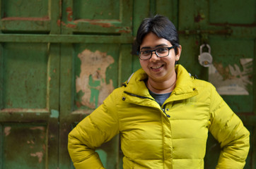 Obraz premium young indian woman against green wooden doors in the background during winters