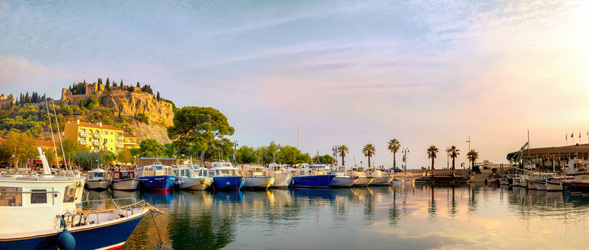 Panoramic landscape with fishing boats in harbour of Cassis at sunset sunlight. France, Provence