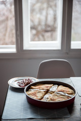 Food preparing in a countryside. Stuffed pancakes, cream and dried meat.