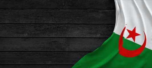 Flag of Algeria, fabric on dark wood.