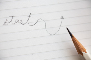 Hand writing " Start " on white paper background, Close up & Macro shot, Selective focus, Stationery concept