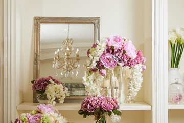 mirror, white and purple flowers in glass vases