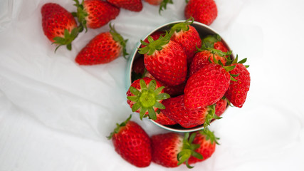 Strawberries in a cup with a few lying around on a table in a greenhouse in Hanayagi Farm, located in the city of Seika. Strawberry picking is one of the most popular activities in winter in Japan.