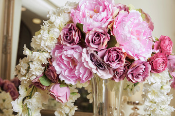 close up of white and purple flowers in glass vase