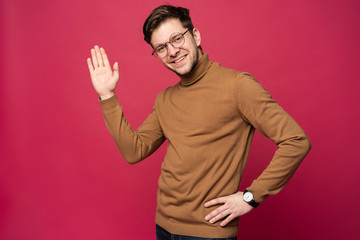 Portrait of smiling man with hand raised in greeting. High five conceptю