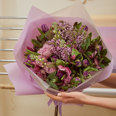 cropped view of florist holding bouquet of tulips, peonies and lilac