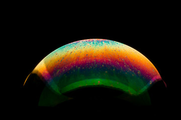 Rainbow colored bubble on a black background.
