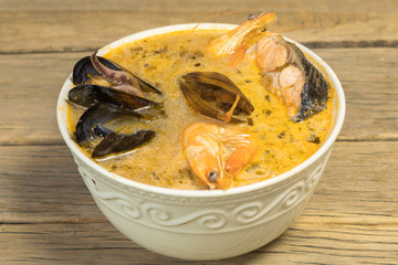 Freshly cooked seafood bouillabaisse soup with shrimps, fish fillets and mussels closeup in a bowl...