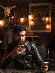 Man with beard holds glass brandy. Macho drinking. Degustation, tasting. Handsome stylish bearded man is drinking whiskey.