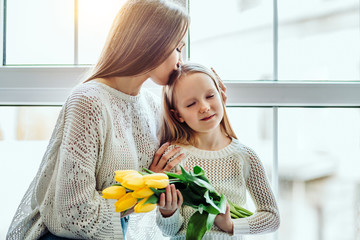 I love you so much!Loving mother and daughter sitting on the window sill at home.