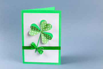 Diy St Patricks Day greeting card made cardboard and paper clovers gray background. Gift idea, decor