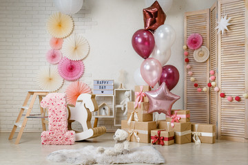 Birthday gold and silver decorations with gifts, toys, garlands and figure for little baby party on...