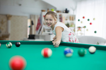 Girl playing billiards.Daughter playing pool