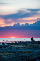 Couple at the seaside during colorful sunset.