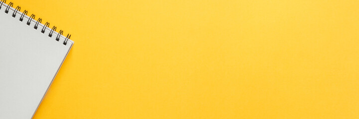 Yellow empty background with space for text. Copy space. Creative concept desk. Top view. Opened notebook. Panorama
