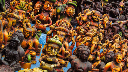Miniature Hindu god statues (Ganesha, Shiva, Buddha) exhibited by a road vendor in South India