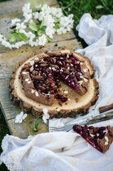 Chocolate cherry galette or pie on a wooden board. Spring or summer picnic in nature.