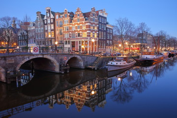 Reflection of crooked and colorful heritage buildings along Brouwersgracht Canal and with Lekkeresluis Bridge on the left, Amsterdam, Netherlands.
