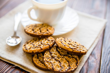 Coffee with biscuits on brown wooden background 