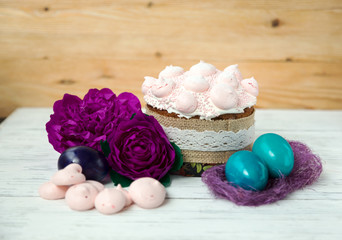Fototapeta na wymiar Easter, festive cake, sweet bize, flowers natural background, painted eggs in a basket.