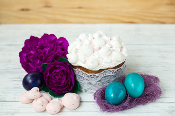 Fototapeta na wymiar Easter, festive cake, sweet bize, flowers natural background, painted eggs.