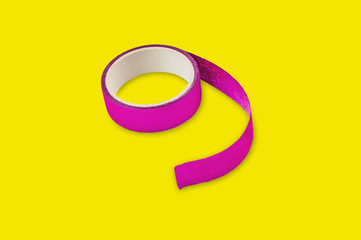 Roll of violet sticky tape in center on yellow background