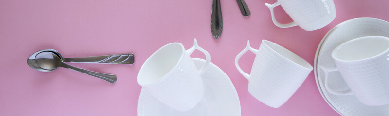 Overhead flat lay view of white clean tableware on pink background