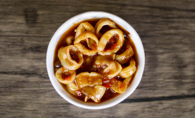 Cumi Saus Padang or Squid in Padang Sauce on wood background. Spicy food from Padang, West Sumatra, Indonesia. 