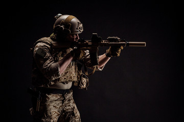 Special forces United States soldier or private military contractor holding rifle. Image on a black background. war, army and people concept