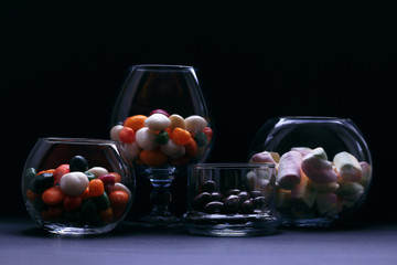 Different colorful fruit and chocolate candies in glass.  Ball candies in glass.             