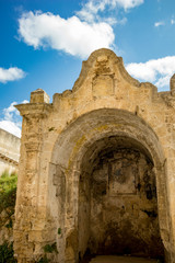 Fototapeta na wymiar MATERA, ITALY - AUGUST 27, 2018: Ancient religious shrine with colorful fresco is abandoned. It could be found at Via Casalnuono street. Sunny summer day with scenery blue sky with white clouds